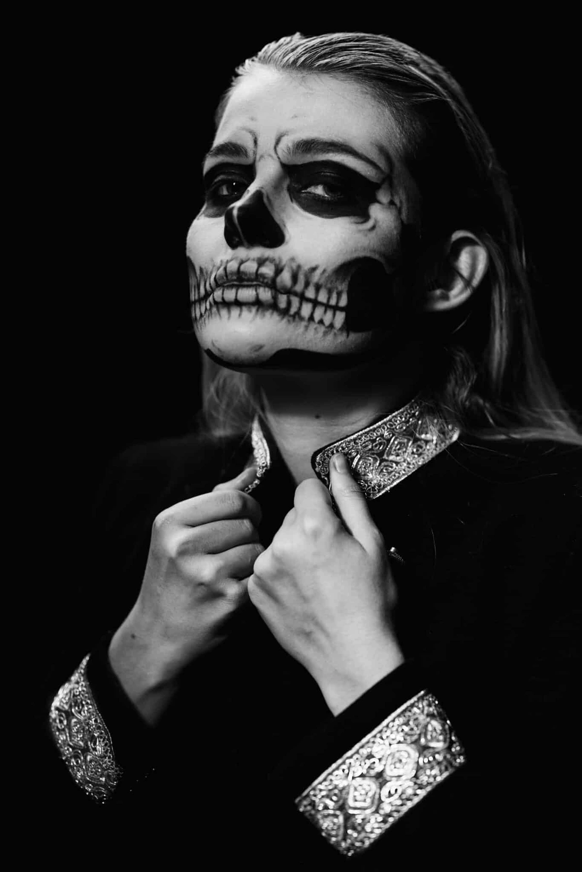 Audrey au maquillage tête de mort, mains sur le col, en noir et blanc